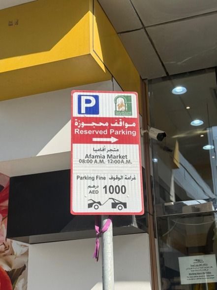 Bilingual reserved-parking signage and pay point in a retail facility